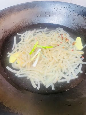 Tagliare la cotenna di maiale preparata in lunghe strisce, sbollentarla nuovamente in acqua fredda per 3 minuti, il che equivale a 