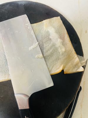 Toglietelo dal fuoco e sciacquatelo con acqua tiepida. Il segreto è raschiare via tutto il grasso all'interno della cotenna di maiale! Non potete saltare questo passaggio, altrimenti l'aspic finito sarà molto unto.