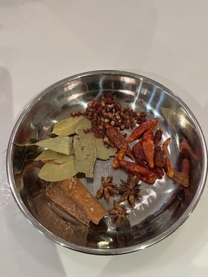 在锅中加入所有如图所示的香料和所有调味品。加入沸水，淹没所有食材。