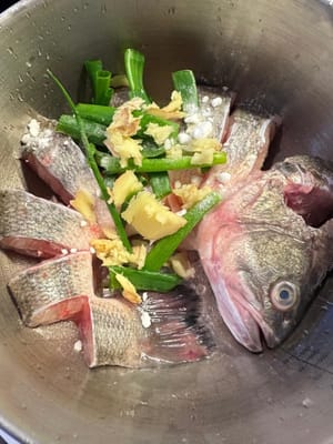Frote bien el pescado con jengibre, cebollín y sal. Este paso elimina el sabor a pescado y sirve como marinada base.