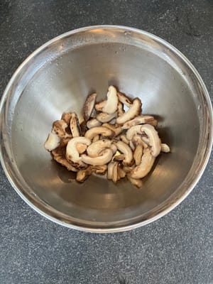 把蘑菇裡的水擠出嚟（保留液體）並切片