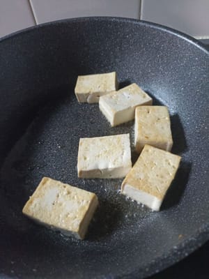 Den Tofu nach einigen Minuten Bratzeit wenden und goldbraun braten.