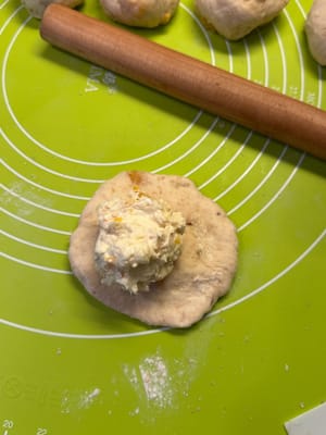 Letakkan bola keju krim di tengah adonan.