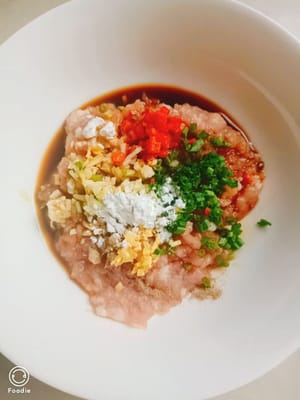 Agregue un poco de sal, 10 g de cebolla verde picada, 10 g de ajo picado, 10 g de jengibre picado y 5 g de chile picante a la carne picada marinada y mezcle bien.