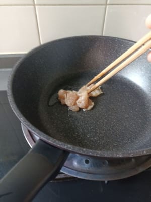 quando l'olio è caldo, aggiungere i pezzi di pollo marinati.