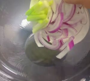 Panaskan minyak dalam wajan lalu masukkan daun bawang dan bawang bombai yang telah disiapkan.
