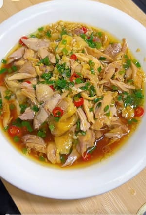 Sepiring ayam suwir minyak daun bawang siap dihidangkan.