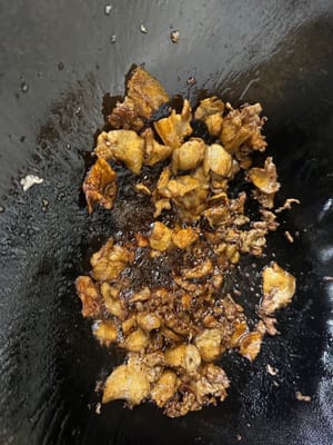 Aggiungere una quantità adeguata di olio nella padella, adagiare le fette di pancetta di maiale e farle rosolare, friggere lentamente a fuoco basso finché l'olio non fuoriesce e la superficie non diventa dorata.