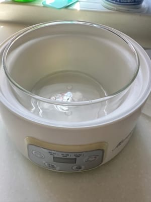 预备一个做乳酪的容器，将牛奶与一小杯酵母倒进玻璃容器里调匀，玻璃容器的外面加少许开水平口，盖上盖子插电调节保温状态10小时