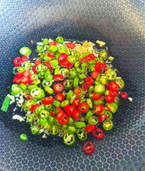 Agregar los pimientos verdes y rojos, la sal y sofreír durante 30 segundos.