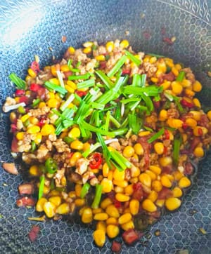 Agregar la salsa y sofreír durante 30 segundos. Espolvorear con cebollino y apagar el fuego. Sofreír una o dos veces y servir.