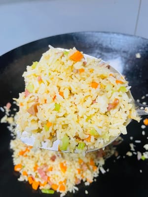 熱鍋放油（推薦使用豬油，可增添炒飯香氣；無豬油時，食用油也可 ），將冷飯倒入鍋中，炒至米飯粒粒分明。接著加入之前炒好的芹菜、紅蘿蔔等配菜，翻炒均勻，再加入1小匙生抽、鹽、少量白糖（提鮮並綜合鹹味）調味，（注意培根腸仔已有鹹味，不要放鹹了）