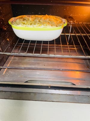 準備可進焗爐的焗飯餐具，將炒好的米飯裝入其中，鋪上薯仔泥（若有製作 ），再撒上馬蘇里拉芝士。將餐具放入預熱至180℃的焗爐，烤15分鐘，至芝士融化、表面呈現誘人色澤即可享用。