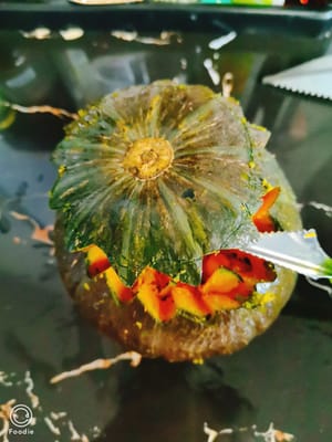 Potong labu kabocha menjadi dua bagian memanjang.