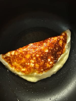 When the eggs are half cooked, fold them in half