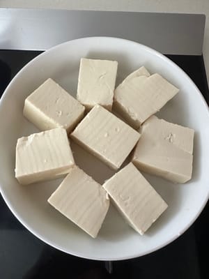 Per prima cosa, dividete il tofu morbido in otto parti e disponetele su un piatto.