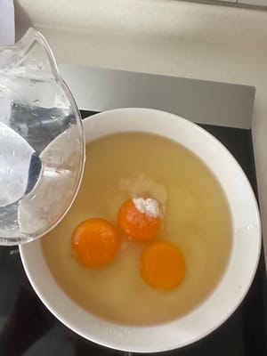 Quindi sbattete tre uova in una ciotola e aggiungete 1,2 volte la quantità di acqua tiepida.