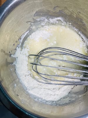 Das Kuchenmehl hineinsieben und mit einem Spatel in einer N-förmigen Bewegung unterheben, bis keine trockenen Mehlkörner mehr vorhanden sind.