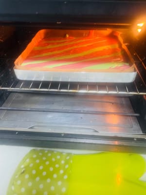 Heizen Sie den Backofen mindestens 10 Minuten lang auf 150 °C (300 °F) vor. Legen Sie eine 28 x 28 cm große Backform mit Backpapier aus.

Hinweis: Jetzt ist Ihr Geschick beim Spritzen von geraden Linien gefragt! Die Größe der Spritzbeutelöffnung und der Druck beim Aufspritzen des Teigs müssen für beide Farben gleich sein, sonst werden die Streifen krumm und bilden ein „S“! Schneiden Sie in jeden Spritzbeutel eine kleine Öffnung und spritzen Sie abwechselnd roten Hefereis- und Matcha-Teig in die Backform, um weihnachtliche Streifen zu gestalten (siehe Abbildung).

Heben Sie die Backform nach dem Aufspritzen an und lassen Sie sie zweimal vorsichtig aus etwa 10 cm Höhe fallen, um die Oberfläche zu glätten (es ist in Ordnung, wenn sich die Farben vermischen). Entfernen Sie größere Luftblasen und backen Sie den Kuchen anschließend 20 Minuten lang auf der mittleren Schiene des vorgeheizten Ofens bei 150 °C (300 °F).

Den gebackenen Kuchen sofort aus dem Ofen nehmen, auf ein Kuchengitter stürzen und, solange er noch warm ist, das Backpapier abziehen. Den Kuchen vollständig auskühlen lassen.