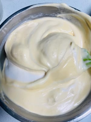 Baiser und Eigelbmasse vermengen
Zuerst ein Drittel des geschlagenen Baisers mit einem Spatel in einer N-förmigen Bewegung unter die Eigelbmasse heben, bis alles gut vermischt ist. Anschließend die Mischung zu den restlichen zwei Dritteln des Baisers geben und erneut in einer N-förmigen Bewegung unterheben, bis alles vollständig vermengt ist und keine weißen Baiserstückchen mehr sichtbar sind.

Durch das Verdünnen der Eigelbmasse vor dem erneuten Unterheben des Baisers wird verhindert, dass dieser zusammenfällt. So kann der Kuchenboden gut aufgehen und die Gefahr von Rissen beim Rollen verringert werden.