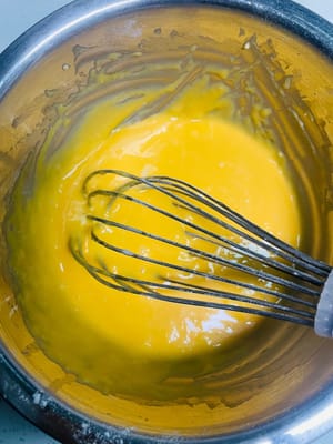 Trennen Sie Eigelb und Eiweiß. Schlagen Sie das Eiweiß in eine saubere, trockene Schüssel und stellen Sie es beiseite. Geben Sie das Eigelb in eine Schüssel mit Mehl und verrühren Sie es mit einer N-förmigen Bewegung, bis eine glatte Masse entsteht.