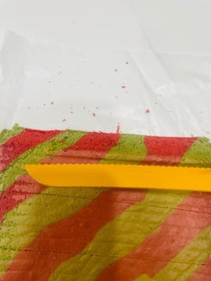 Während der Kuchenboden abkühlt, die Sahne mit dem Zucker steif schlagen (im Sommer sollte die Raumtemperatur unter 20 °C liegen). Die Erdbeeren waschen und abtrocknen.

Den vollständig abgekühlten Kuchenboden mit der Unterseite nach oben legen und mit einem Messer an beiden Seiten im 45°-Winkel einschneiden. Anschließend in der Mitte einige flache Linien leicht einritzen (nicht ganz durchschneiden).