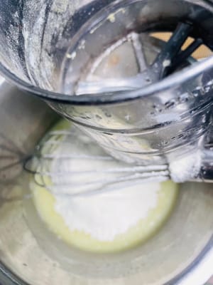 Das Kuchenmehl hineinsieben und mit einem Spatel in einer N-förmigen Bewegung unterheben, bis keine trockenen Mehlkörner mehr vorhanden sind.