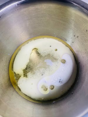 Bereiten Sie den Teig vor. Geben Sie 20 g weißen Zucker, 45 g Maisöl und 45 g Milch in eine Schüssel mit Eigelb und verquirlen Sie die Zutaten, bis eine homogene Emulsion ohne sichtbare Öltropfen entsteht.