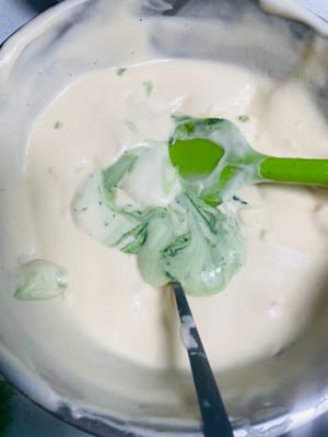 Den Teig teilen und die Farben anpassen. Den gemischten Kuchenteig in zwei Portionen teilen. Eine Portion in den vorbereiteten Teig mit rotem Hefe-Reis-Pulver und die andere in den Matcha-Teig geben. Jede Portion mit einem Spatel zügig in einer N-förmigen Bewegung unterheben, bis alles gut vermischt ist. Anschließend die Mischung in zwei Spritzbeutel füllen. Mit Spritzbeuteln lassen sich die weihnachtlichen Streifen leichter aufspritzen.