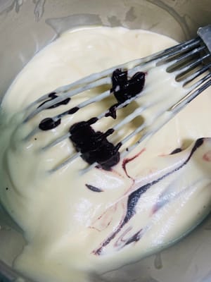 Den Teig teilen und die Farben anpassen. Den gemischten Kuchenteig in zwei Portionen teilen. Eine Portion in den vorbereiteten Teig mit rotem Hefe-Reis-Pulver und die andere in den Matcha-Teig geben. Jede Portion mit einem Spatel zügig in einer N-förmigen Bewegung unterheben, bis alles gut vermischt ist. Anschließend die Mischung in zwei Spritzbeutel füllen. Mit Spritzbeuteln lassen sich die weihnachtlichen Streifen leichter aufspritzen.