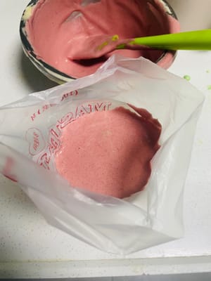 Den Teig teilen und die Farben anpassen. Den gemischten Kuchenteig in zwei Portionen teilen. Eine Portion in den vorbereiteten Teig mit rotem Hefe-Reis-Pulver und die andere in den Matcha-Teig geben. Jede Portion mit einem Spatel zügig in einer N-förmigen Bewegung unterheben, bis alles gut vermischt ist. Anschließend die Mischung in zwei Spritzbeutel füllen. Mit Spritzbeuteln lassen sich die weihnachtlichen Streifen leichter aufspritzen.