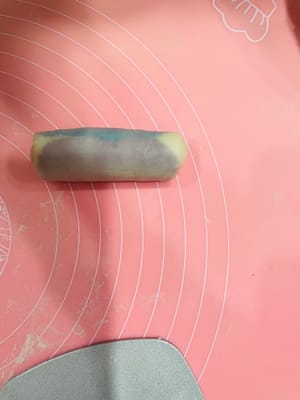 Enrobage de la pâte à base d’huile, premier étalage et repos

Déposez trois portions de 9 g de pâte à base d’huile (ou une portion de 27 g) au centre de la pâte à l’eau, appuyez légèrement avec la paume de la main, puis repliez-la sur elle-même de haut en bas et de gauche à droite. Retournez-la et aplatissez-la délicatement avec un rouleau à pâtisserie, puis tapotez-la avec la main pour uniformiser la pâte à base d’huile et obtenir une surface plus lisse et esthétique. Ensuite, comme pour l’étalage de la pâte à l’eau, roulez-la dans le sens de la longueur, en veillant à ne pas la rouler d’avant en arrière. Retournez-la à nouveau et roulez-la. Ce roulage permet de mieux distinguer les couches de pâte à l’eau et de pâte à base d’huile, ce qui donnera une texture feuilletée plus belle à la cuisson.

Après avoir enrobé toute la pâte à base d’huile avec la pâte à l’eau et l’avoir roulée, laissez reposer 15 minutes. Ce temps de repos est essentiel pour éviter que la pâte ne se déchire si vous la roulez sans cesse.