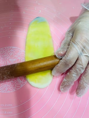 Deuxième étalage et façonnage. Prenez la pâte étalée et façonnée une première fois, aplatissez-la légèrement avec vos mains, puis roulez-la sur elle-même (sans la rouler d'avant en arrière), comme pour une pâte à l'huile. Retournez-la et roulez-la à nouveau, couvrez-la de film alimentaire et réservez. Essayez de l'aplatir légèrement au rouleau à pâtisserie avant de l'étaler. Cela permettra d'obtenir une pâte à l'huile plus homogène et une couleur plus uniforme. Ce deuxième étalage et façonnage sert à créer davantage de couches et à accentuer le feuilletage.