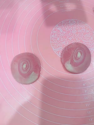 切割
待全部做好后,准备一把锋利的小刀,取其中一个面剂子,从中间迅速切开,然后切面向上(面向自己),用手掌压扁一下。刀要锋利,不然切面不整齐,影响后面的形状。