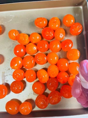 Retirez les jaunes d'œufs salés et rincez-les soigneusement pour enlever la membrane blanche qui les recouvre, car elle risque de leur donner une odeur de poisson et d'altérer leur goût. Vaporisez ensuite un peu d'alcool fort (plus de 50 degrés) pour atténuer l'odeur de poisson et parfumer les jaunes. Enfournez-les ensuite à 180 °C (thermostat 6) pendant 8 minutes, sans préchauffage. Une fois cuits, retirez-les du four et réservez-les.