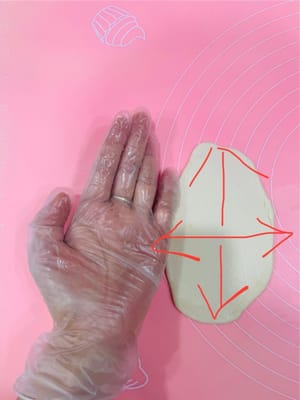 油皮擀制
取油皮一个,将其稍微压扁,向上、下各擀一下,再向左、右擀一下,大约手巴掌宽的大小。这样擀是为了让油皮均匀,方便包油酥。