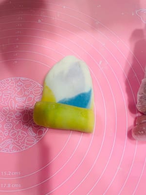 Deuxième étalage et façonnage. Prenez la pâte étalée et façonnée une première fois, aplatissez-la légèrement avec vos mains, puis roulez-la sur elle-même (sans la rouler d'avant en arrière), comme pour une pâte à l'huile. Retournez-la et roulez-la à nouveau, couvrez-la de film alimentaire et réservez. Essayez de l'aplatir légèrement au rouleau à pâtisserie avant de l'étaler. Cela permettra d'obtenir une pâte à l'huile plus homogène et une couleur plus uniforme. Ce deuxième étalage et façonnage sert à créer davantage de couches et à accentuer le feuilletage.