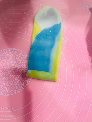 Deuxième étalage et façonnage. Prenez la pâte étalée et façonnée une première fois, aplatissez-la légèrement avec vos mains, puis roulez-la sur elle-même (sans la rouler d'avant en arrière), comme pour une pâte à l'huile. Retournez-la et roulez-la à nouveau, couvrez-la de film alimentaire et réservez. Essayez de l'aplatir légèrement au rouleau à pâtisserie avant de l'étaler. Cela permettra d'obtenir une pâte à l'huile plus homogène et une couleur plus uniforme. Ce deuxième étalage et façonnage sert à créer davantage de couches et à accentuer le feuilletage.