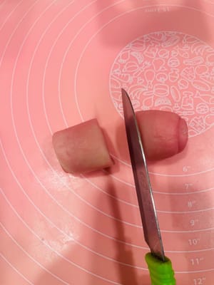 Découpe

Une fois toutes les boules de pâte préparées, prenez-en une et coupez-la rapidement en deux dans le sens de la longueur. Ensuite, face coupée vers le haut (face à vous), aplatissez-la légèrement avec la paume de votre main. Le couteau doit être bien aiguisé, sinon la coupe sera irrégulière et cela affectera la forme finale.