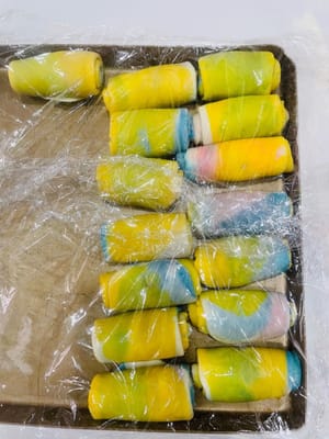 第二次擀卷
取第一次擀好卷好的面团,稍稍用手压扁,向上、下各擀一下(千万不要来回擀),就像擀油皮那样,然后再反过来卷起来,盖上保鲜膜备用。尽量用擀面杖先压扁再擀,这样可以让油酥更均匀,包出来的颜色会更漂亮。第二次擀卷是为了让层次更多,起酥更明显。