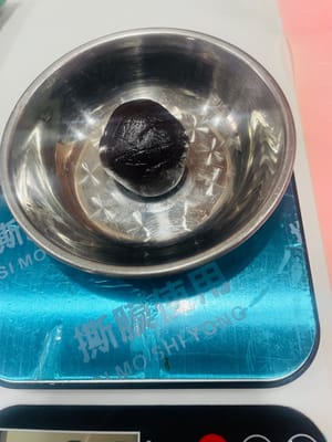 Divisez la pâte de haricots rouges en portions de 30 g et formez des boulettes. La pâte de haricots rouges est essentielle pour atténuer le goût salé de la farce de porc effiloché et de jaune d’œuf ; répartissez-la en portions et garnissez-en les boulettes de farce.