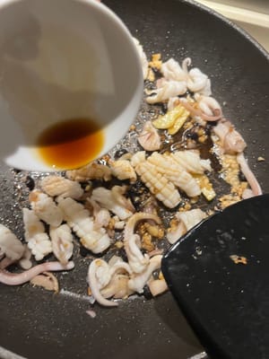 Ajoutez la sauce soja et la sauce aux huîtres immédiatement après avoir versé les calamars dans la casserole