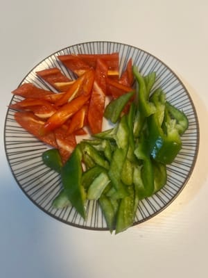 Coupez les poivrons verts et rouges en petits morceaux