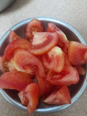 Tomaten in Stücke schneiden