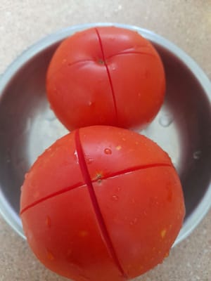 2 Tomaten waschen, halbieren, ca. 2 Minuten kochen, herausnehmen, anschließend die Tomaten häuten und die Haut entfernen.