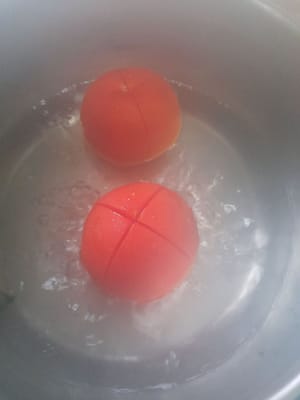 2 Tomaten waschen, halbieren, ca. 2 Minuten kochen, herausnehmen, anschließend die Tomaten häuten und die Haut entfernen.