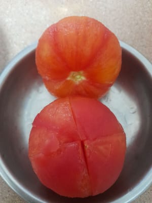 2 Tomaten waschen, halbieren, ca. 2 Minuten kochen, herausnehmen, anschließend die Tomaten häuten und die Haut entfernen.