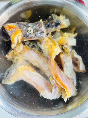 まず、塩漬けした魚をきれいな水に約 12 時間浸します。余分な塩分を取り除くために水を数回交換します。そうしないと、塩辛すぎて食べられなくなってしまいます。