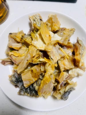 お皿を用意し、まず豚バラ肉を下に敷き、その上にマリネした魚を並べます。最後にマリネ液と生姜のスライスを注ぎます。香りを一滴も逃がさないように。