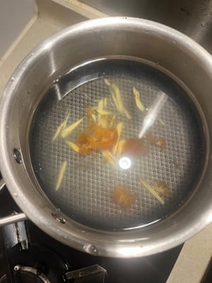 Agregue 600 ml de agua a la olla, agregue jengibre rallado y agua con gelatina de yema de huevo salada.